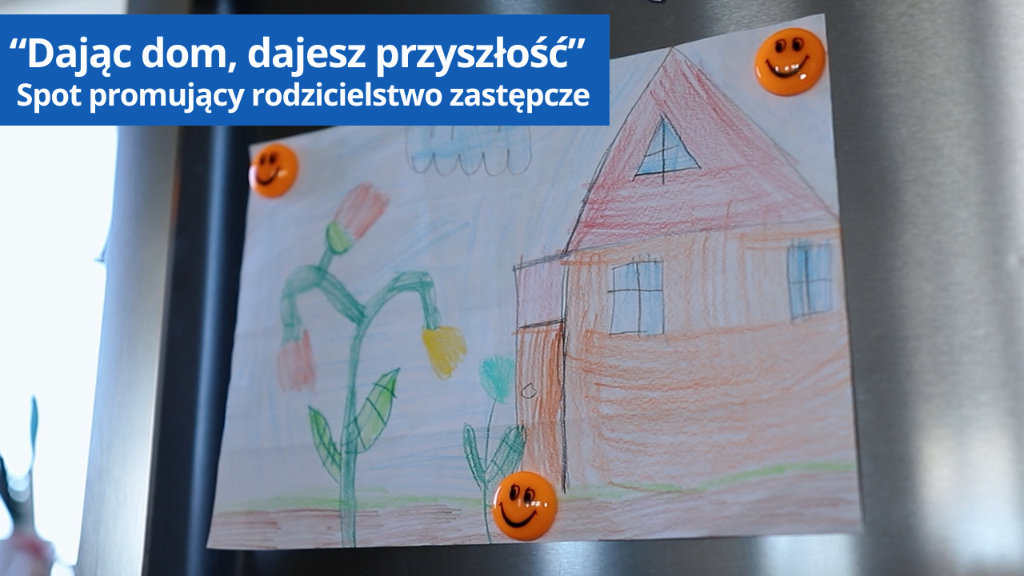 Rysunek dziecka przedstawiający dom i kwiaty zawieszony na lodówce