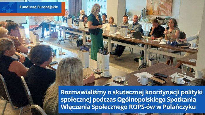 Uczestnicy spotkania siedzą na sali konferencyjnej przy stołach