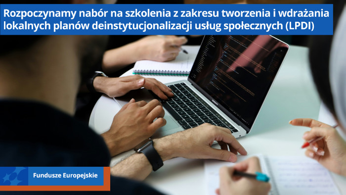 Ręcze czterech oosób siedzących przy stole. Jedna osoba pracuje na laptopie. Pozostałe piszą w notesach.