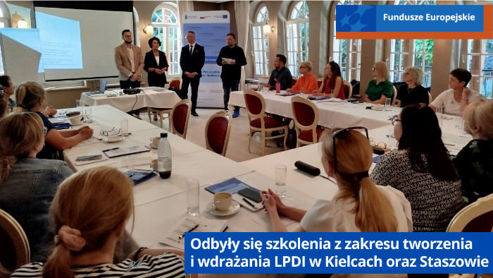 Uczestnicy szkolenia siedzą przy stołach