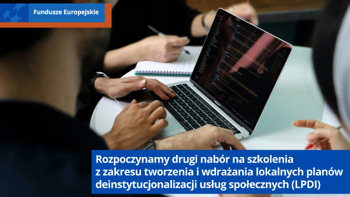 Ręcze czterech oosób siedzących przy stole. Jedna osoba pracuje na laptopie. Pozostałe piszą w notesach.