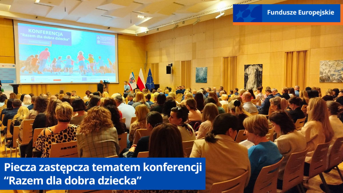 Sala w której odbyła się konferencja Razem dla dobra dziecka. Widok z tyłu sali. Uczestnicy siedzą w rzędach. W głębi ekran z prezentacją